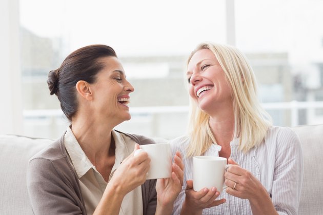 Women gossiping while having coffee in living room