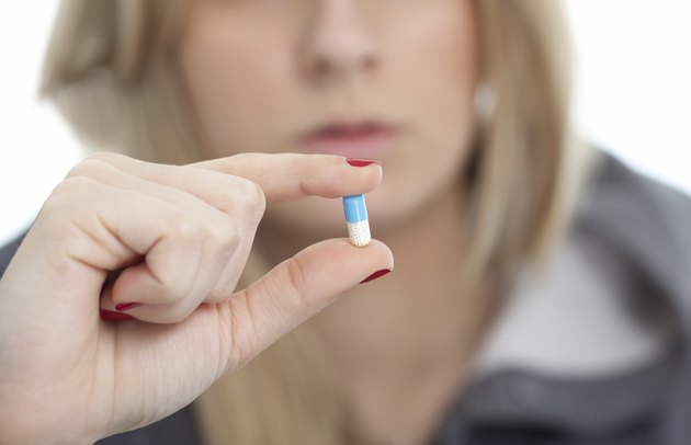 young girl holding a pill