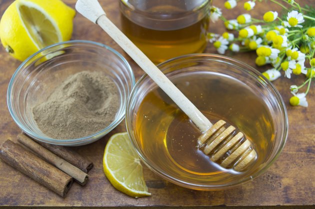 Honey and cinnamon in glass vessels on a table