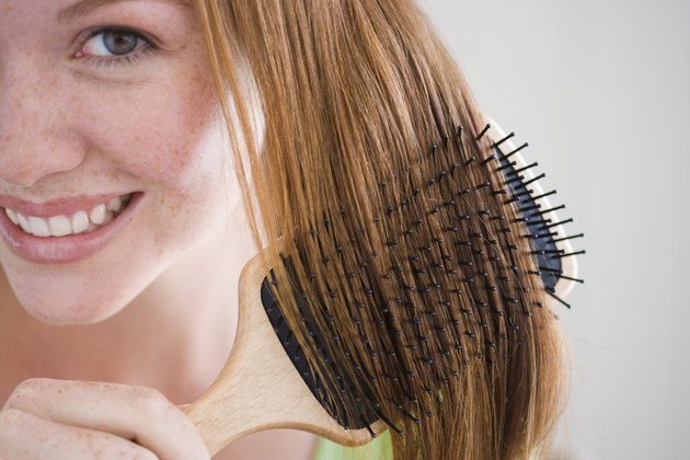Smiling woman combing her hair