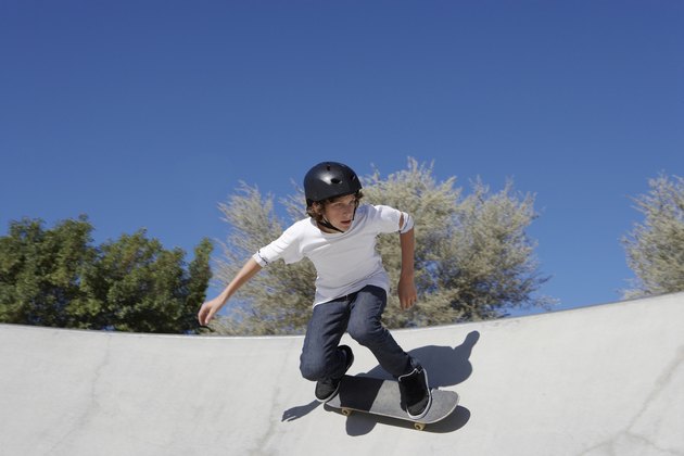 Teenage boy (16-17) skateboarding at skate park