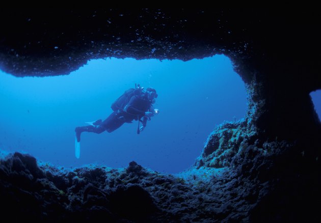 view through a sea cave of a scuba diver exploring