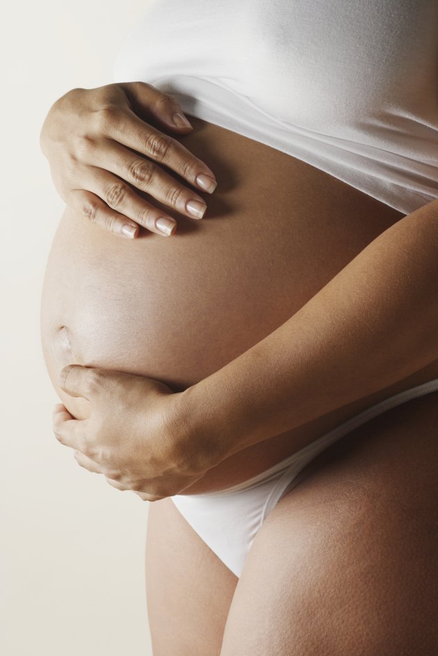 Pregnant woman touching abdomen