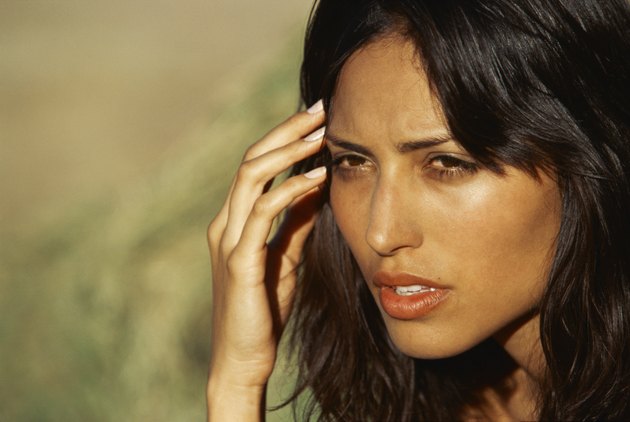 close-up of a young woman holding her head in her hand