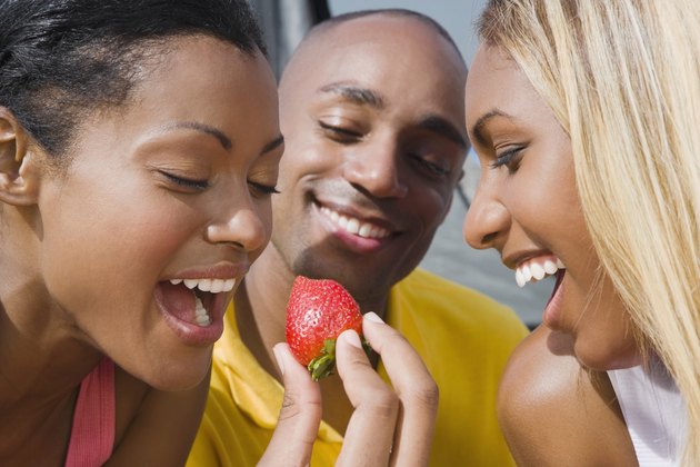 Hispanic woman eating strawberry