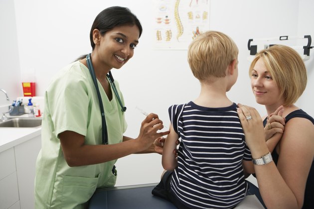 Mother supporting boy receiving injection
