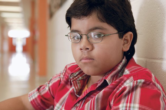 Boy sitting in school hallway