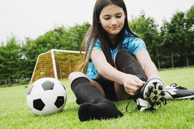 Girl tying soccer cleat