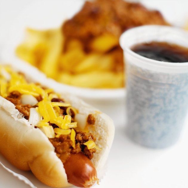 Close-up of hotdog and chili french-fries with cold drink