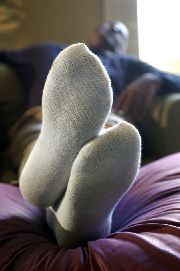 Feet of man resting in chair