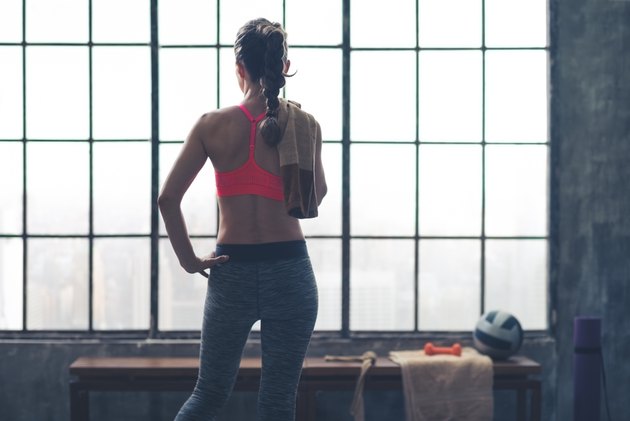 Rear view of woman holding towel in loft gym