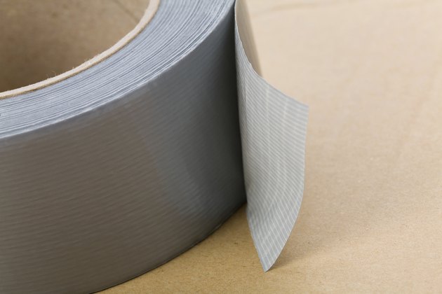 A roll of grey duct tape on a brown surface
