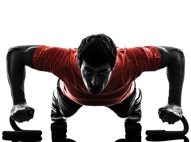 one man exercising fitness workout push ups in silhouette on white background