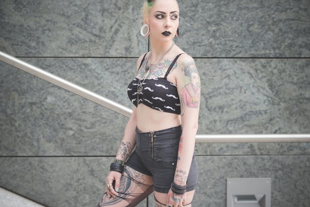 Portrait of young female tattooed punk on subway stairs