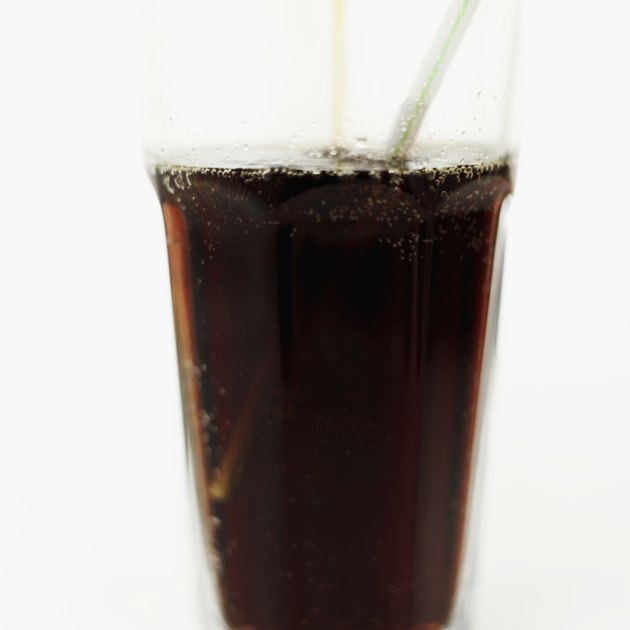 Close-up of a glass of a cola with a straw