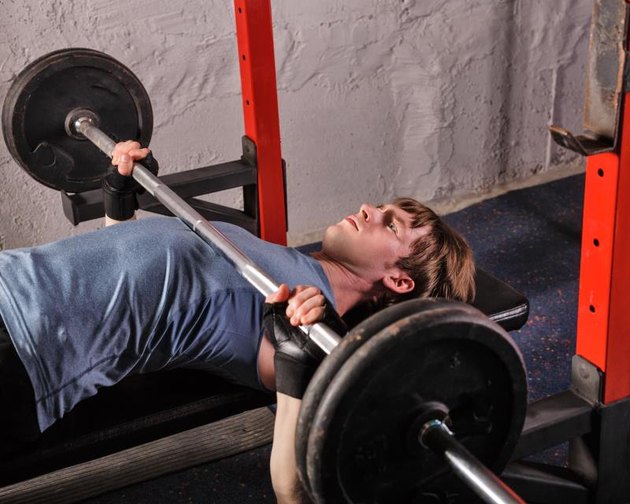 Man doing a bench press with a barbell. Healthy lifestyle concept. Fitness club.