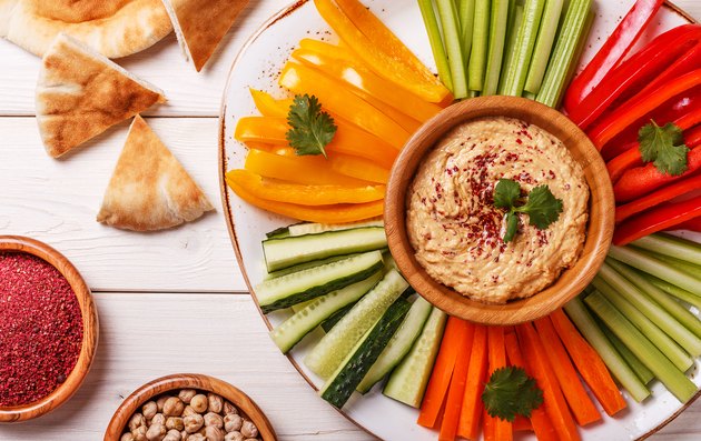 Homemade hummus with assorted fresh vegetables and pita bread.