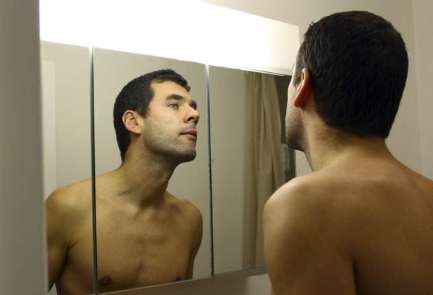 Man's reflection in the bathroom mirror