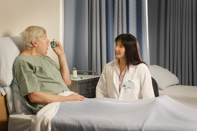 A health care professional supervises patient using inhaler