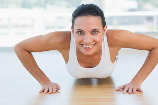A fit woman does push-ups.
