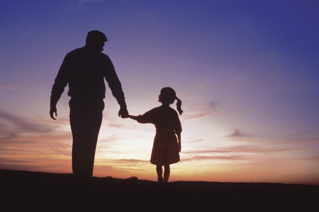 Silhouette of father and daughter walking