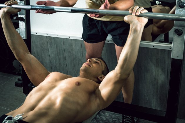 Man doing weight lifting with personal trainer