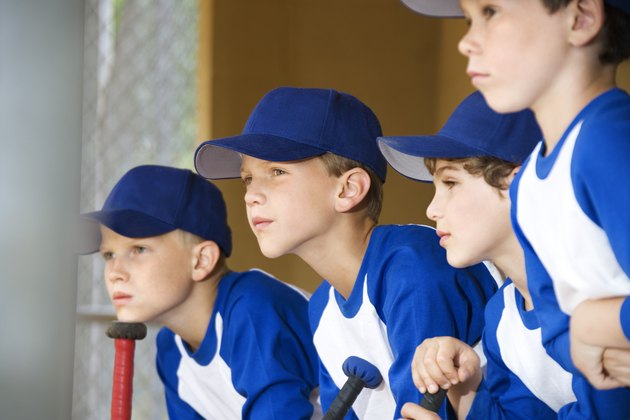 Young baseball players sitting in dugout