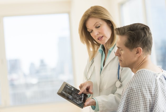 Doctor showing digital tablet to patient in clinic