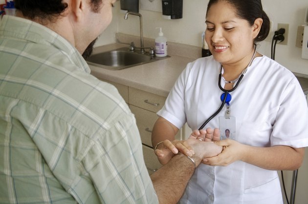 Female nurse checking the pulse of a patient and smiling