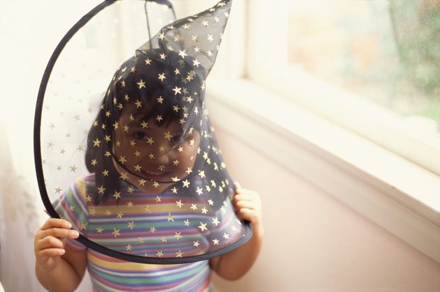 Girl wearing funny hat near window
