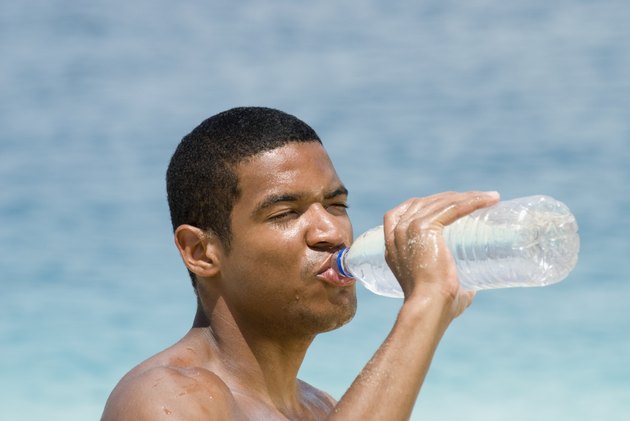 Hispanic man drinking water bottle