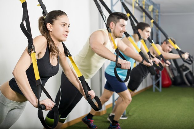 People at gym doing elastic rope exercises