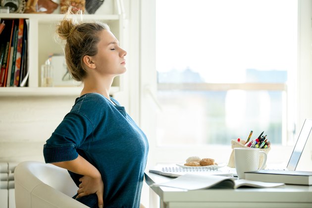 Portrait of an attractive woman at the table backache pose