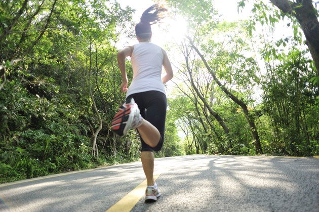 healthy lifestyle fitness sports woman running at mountain forest road