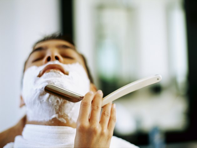 barber shaving a young man