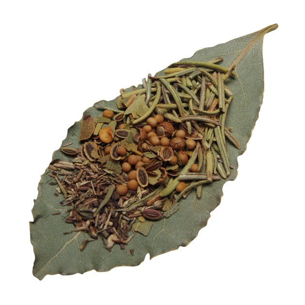 Assorted dried herbs and spices on bay leaf