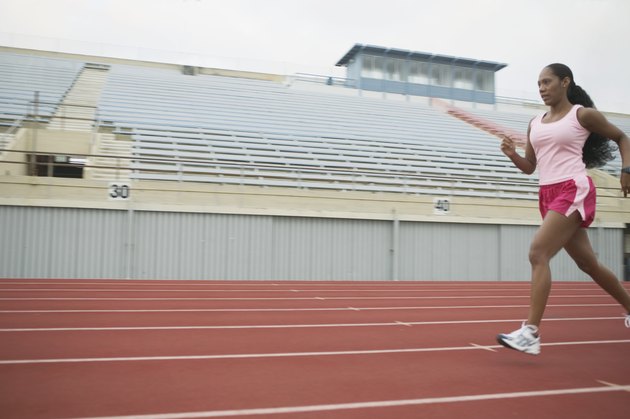 Side profile of an athlete running on the running track