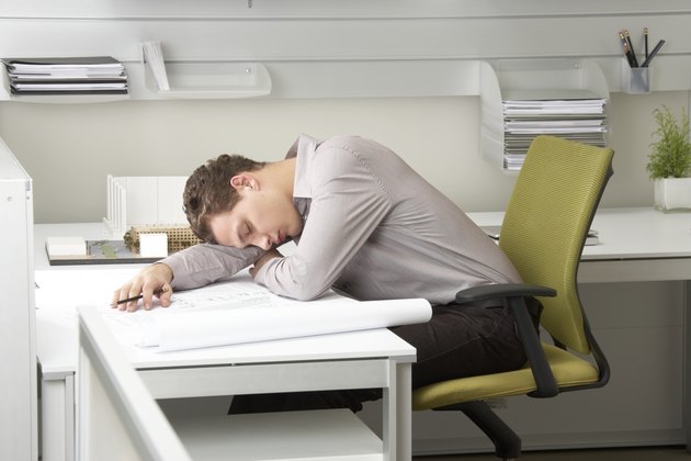 Young businessman asleep on desk