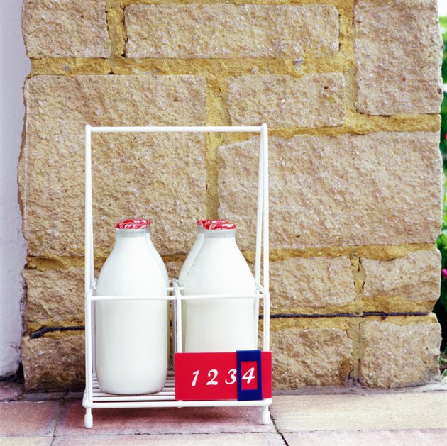 Four milk bottles in holder, close-up