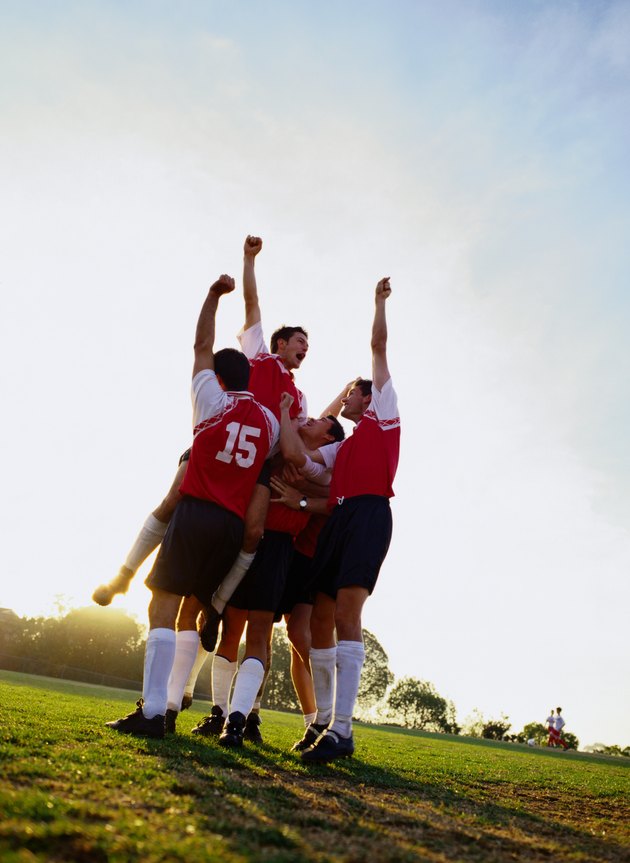 Soccer team raising their arms in triumph