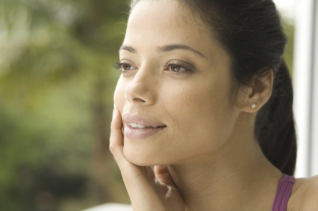 Close-up of young woman with hand on cheek
