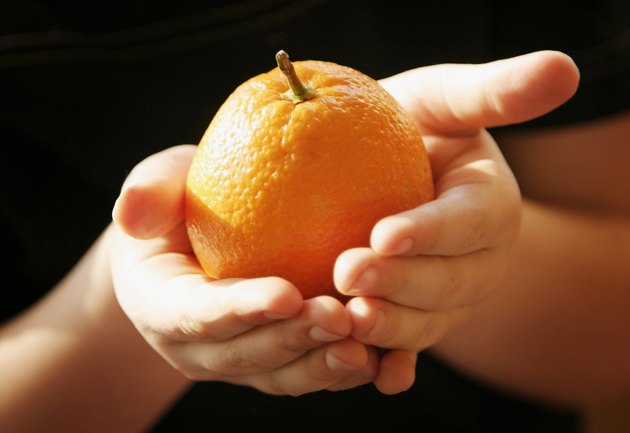 Hands holding an orange