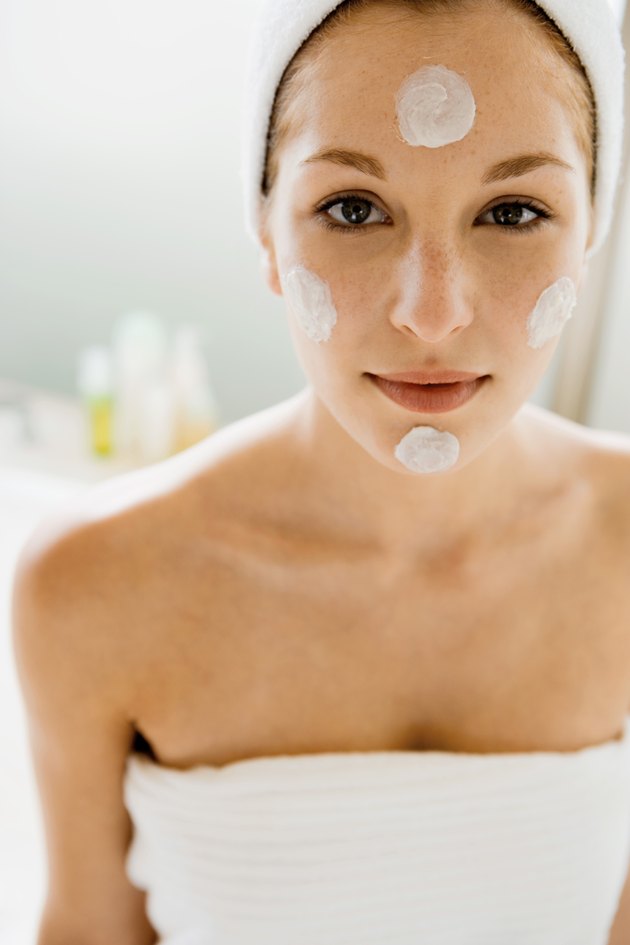 Woman with blots of moisturizer on her face