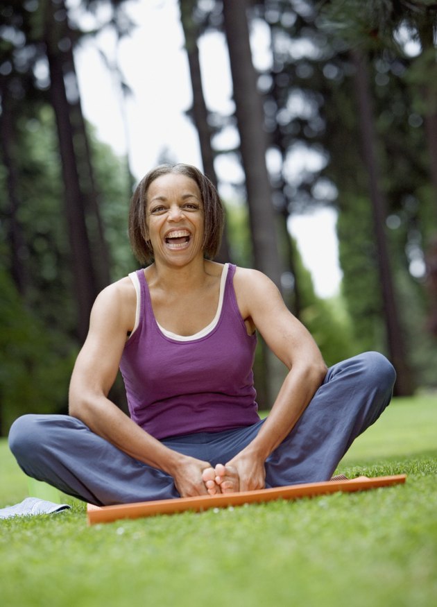 Senior woman stretching in park