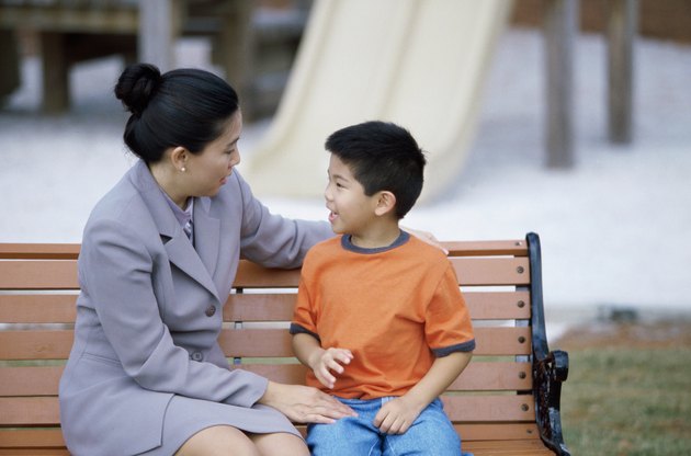 Mother sitting with her son on a park bench