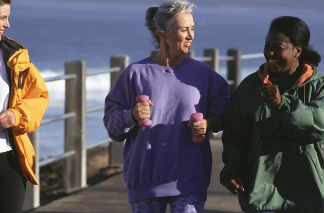 Three women walking along pier, talking
