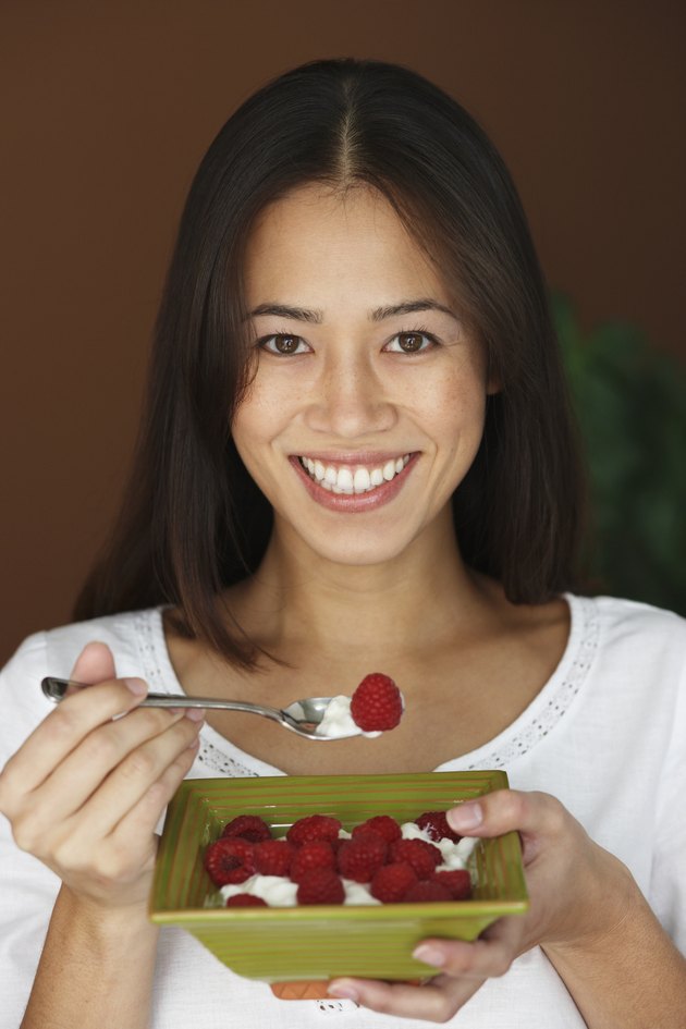 Asian woman eating fruit and cream