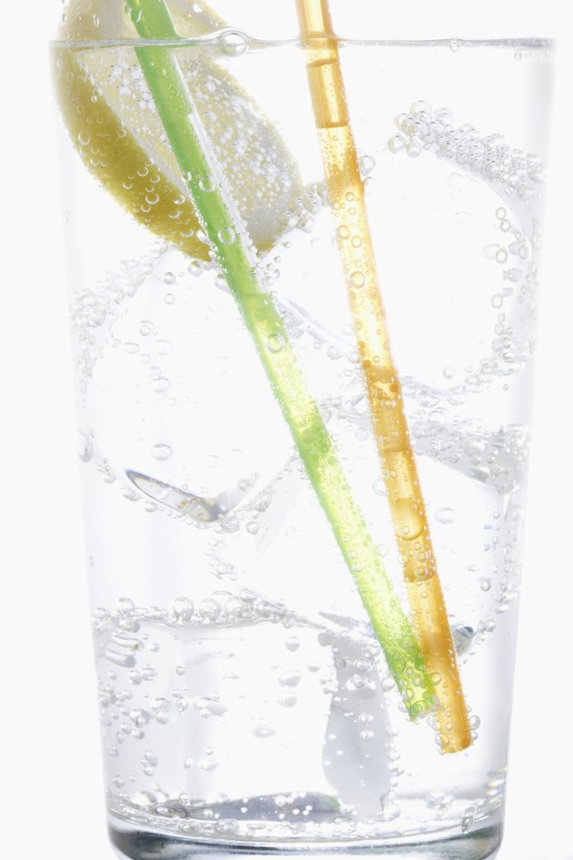 Straws, lemon and ice in carbonated water