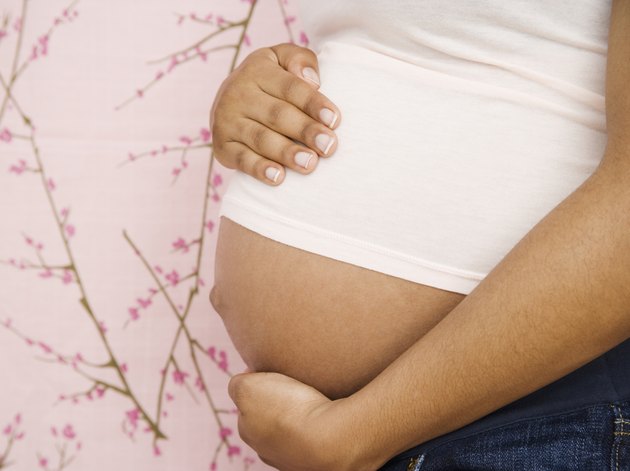 Pregnant African American woman with hands on belly