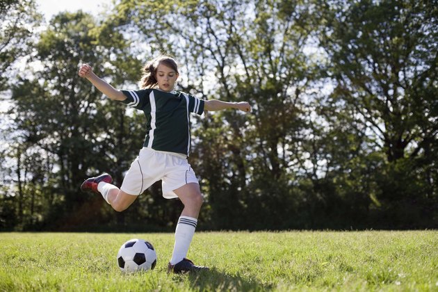 Girl kicking soccer ball